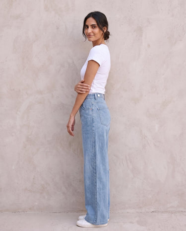The Tiela Adjustable Jeans in blue — wide-leg jeans, side view on model