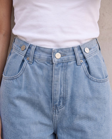 The Tiela Adjustable Jeans in blue — close-up of the waistband and adjustable buttons