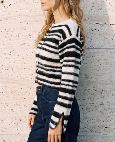 Tilia Knit Cardigan in white and black — side profile on model showing the cropped length and split cuffs