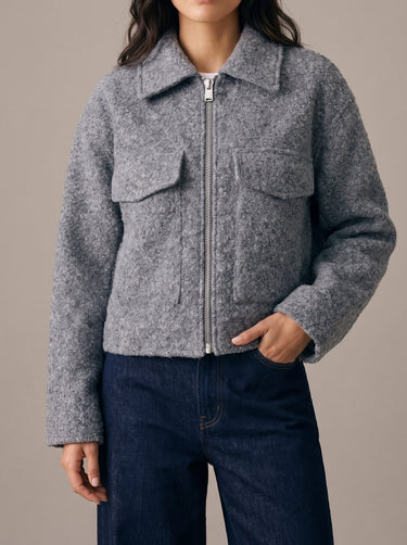 Zoe Coat in gray — cropped tweed-effect jacket zipped up, front view on model with hand in pocket